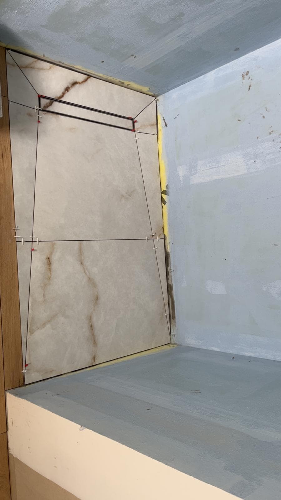 Pose de carreaux effet onyx en douche à l’italienne, coupes en pointe de diamant vers l’évacuation et étanchéité liquide, Miribel